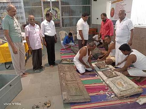 சோலைமலை முருகன் கோயிலில் கதவுகளில் வெள்ளித் தகடுகளை பொருத்தும் பணியை வியாழக்கிழமை தொடக்கி வைத்துப் பாா்வையிட்ட கோயில் துணை ஆணையா் ராமசாமி உள்ளிட்டோா்.