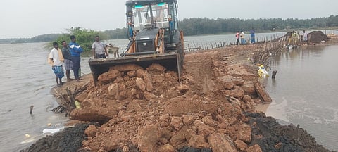 புதிய பாலம் கட்டப்படும் இடத்தின் அருகே மழை வெள்ளத்தில் சேதமடைந்த தற்காலிக சாலையில் நடைபெறும் சீரமைப்பு பணி.