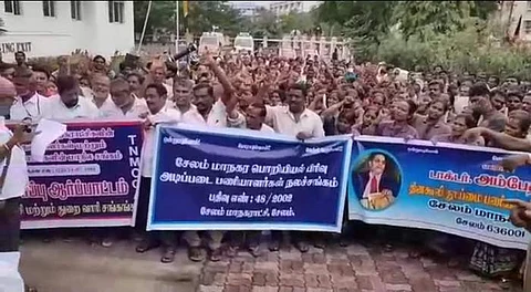 சேலம் மாநகராட்சியில் ஆள்குறைப்பு நடவடிக்கையை கண்டித்து தர்னா போராட்டத்தில் ஈடுபட்ட மாநகராட்சி ஊழியர்கள்.