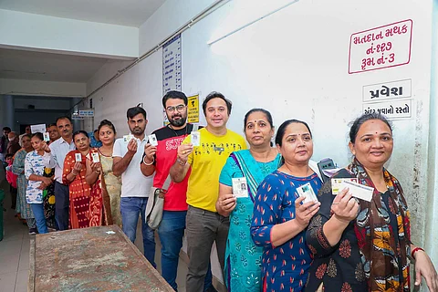 வாக்காளர் அடையாள அட்டையுடன் வாக்களிக்க வரிசையில் காத்திருக்கும் மக்கள்.
