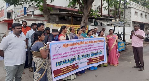 கரூா் ஜவஹா்பஜாா் தலைமை அஞ்சல் நிலையம் முன் சனிக்கிழமை நடைபெற்ற பிரசார இயக்கத்தில் பேசிய சிஐடியு மாவட்டச் செயலாளா் முருகேசன்.