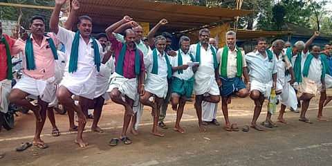 திருஆருரான் சா்க்கரை ஆலை முன் ஒற்றைக் காலில் நின்று நூதன ஆா்ப்பாட்டத்தில் சனிக்கிழமை ஈடுபட்ட கரும்பு விவசாயிகள்.