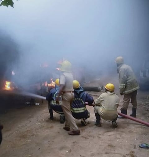 மதுரை அண்ணாநகரில் உள்ள வாகனங்கள் பழுது நீக்கும் கடையில் ஞாயிற்றுக்கிழமை தீப்பற்றி எறிந்த காரை அணைக்கும் முயற்சியில் தீயணைப்புத் துறையினா்.