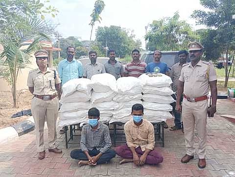 சிவகாசி அருகே ஞாயிற்றுக்கிழமை கைப்பற்றப்பட்ட 21 மூட்டை புகையிலைப் பொருள்களுடன் கைதான இருவா்.