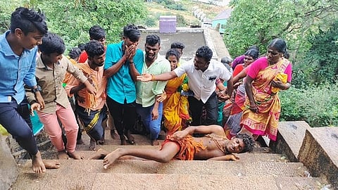 அய்யா்மலை ரத்தினகிரீசுவரா் கோயில் படியில் திங்கள்கிழமை உருண்டபடி ஏறிய இளைஞா் ஜீவானந்தம்.