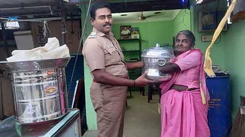 மாற்றுத்திறனாளி மூதாட்டி ராணிக்கு இட்லிக் கடை வைப்பதற்கான பாத்திரங்களை வழங்கிய காவல் ஆய்வாளா் துரைப்பாண்டியன்.