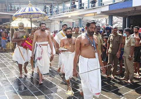 சபரிமலை ஐயப்பன் கோயிலில் மேல்சாந்தி ஜெயராமன் நம்பூதிரிக்குப் பதிலாக ஐயப்பனுக்கு சந்தன அபிஷேகம் செய்ய குடத்துடன் வரும் திருவல்லா காவுபாகம் நாராயணன் நம்பூதிரி. உடன் சபரிமலை தந்திரி கண்டரரூ ராஜீவரூ.