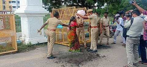 தூத்துக்குடி மாவட்ட ஆட்சியா் அலுவலகத்தில் தீக்குளிக்க முயற்சித்த பெண்ணின் மீது தண்ணீரை ஊற்றி காப்பாற்றும் போலீசார்