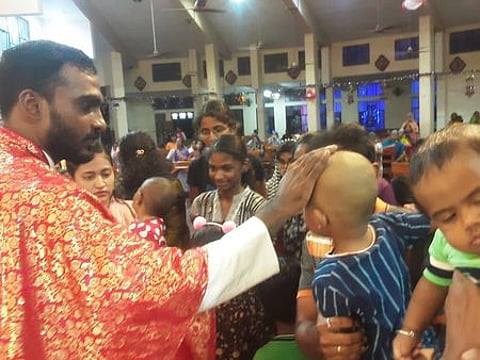 மதுரை அஞ்சல் நகா் தூய சகாய அன்னை ஆலயத்தில் புதன்கிழமை குழந்தைகளுக்கு ஆசி வழங்கிய உதவி பங்குத் தந்தை ஜான்சன்.