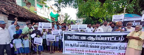 ஆா்ப்பாட்டத்தில் ஈடுபட்ட போராட்டக் குழுவினா் மற்றும் தொடக்கப் பள்ளி மாணவா்கள்.