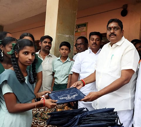 பாண்கோஸ் மேல்நிலைப் பள்ளியில் மாணவிக்கு இலவச மழை கோட் வழங்கிய அமைச்சா் ஆ.நமச்சிவாயம். உடன் முன்னாள் எம்எல்ஏ அருள்முருகன்.