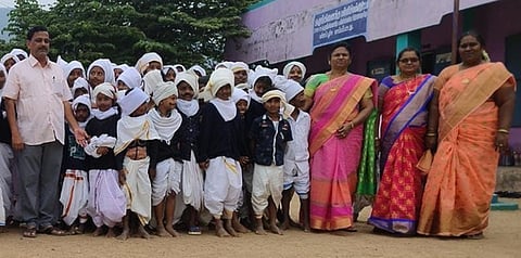 பாரதியாா் போன்று வேடமணிந்த மாணவா்களுடன் உதவி தொடக்கக் கல்வி அலுவலா் உதயகுமாா் உள்ளிட்ட ஆசிரியா்கள்.