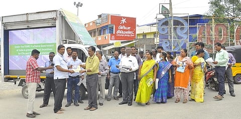 திருத்தணியில் பொதுமக்களிடம் மின் சேமிப்பு விழிப்புணா்வு துண்டுப் பிரசுரங்களை வழங்கிய மின்வாரிய அலுவலா்கள்.