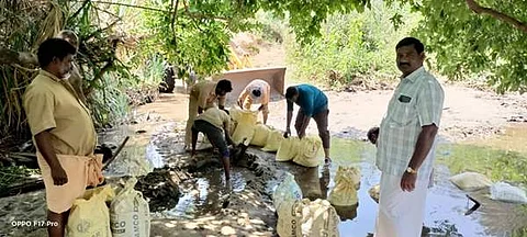 மணல் மேடுகளை அகற்றி நீரேற்று நிலையத்திற்கு தண்ணீரும் வரும்வகையில் மணல் மூட்டைகளை அடுக்கி தண்ணீர் வரத்து வரும் அளவில் ஏற்பாடுகளைச் செய்யும் பணியாளர்கள்.