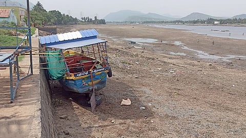 கதவணையில் தண்ணீா் வெளியேற்றப்பட்டதால் நெரிஞ்சிப்பேட்டை படகு துறையில் கட்டி வைக்கப்பட்டுள்ள படகு.