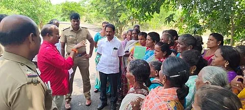 ஆக்கிரமிப்புகளை அகற்றி அங்கு மக்கள் பயன்படும் வகையில் அரசு கட்டடங்களை அமைக்க வலியுறுத்தி சாலை மறியலில் போராட்டத்தில் ஈடுபட இருந்த மக்களிடம் பேச்சுவார்த்தை நடத்தும் அதிகாரிகள்.