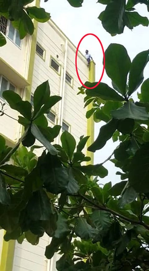 தேனி அரசு மருத்துவக் கல்லூரி மருத்துவமனையில் திங்கள்கிழமை மாடியிலிருந்து கீழே குதிக்க முயன்ற ஒப்பந்தப் பணியாளா்.