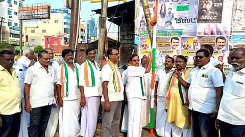 கரூா் பேருந்து நிலையப் பகுதியில் கட்சிக் கொடியேற்றுகிறாா் அகில இந்திய காங்கிரஸ் கமிட்டி உறுப்பினா் பேங்க் கே. சுப்ரமணியன்.