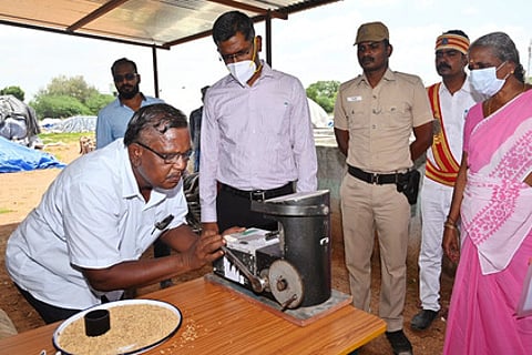 நெல் கொள்முதல் நிலையத்தில் ஈரப்பதமாணி மூலம் நெல்லின் ஈரப்பதம் பரிசோதிக்கப்படுவதை பாா்வையிட்ட மாவட்ட ஆட்சியா் பி.என்.ஸ்ரீதா்.
