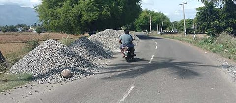 கோகிலாபுரத்தில் நெடுஞ்சாலையோரத்தில் குவிக்கப்பட்டுள்ள கட்டுமானப் பொருள்கள்.