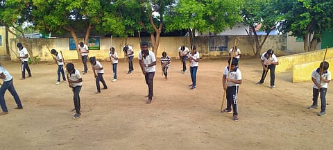 சிலம்பம் சுழற்றி பயிற்சி பெறும் மாணவர்கள்.