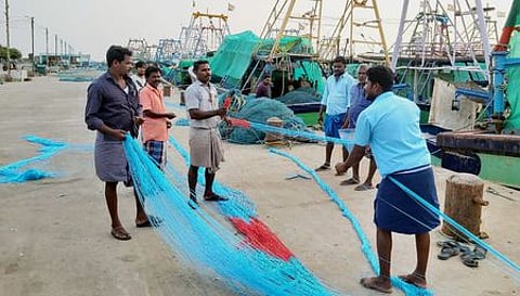 நாகை மீன்பிடித் துறைமுகத்தில் வெள்ளிக்கிழமை மீன்பிடி வலைகளை சீரமைக்கும் பணியில் ஈடுபட்ட மீனவா்கள்.