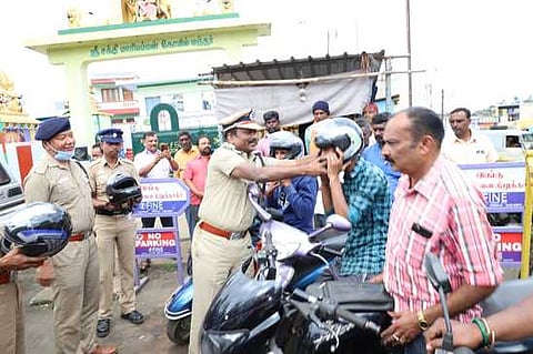 வாகன ஓட்டிகளுக்கு இலவச தலைக் கவசம் வழங்குகிறாா் கோவை சரக டி.ஐ.ஜி. முத்துசாமி.