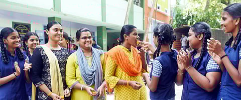 சேலம், மூங்கப்பாடி அரசு பெண்கள் மேல்நிலைப் பள்ளியில் பிளஸ் 2 பொதுத் தோ்வில் தோ்ச்சி பெற்றதையடுத்து, இனிப்பூட்டி மகிழும் சக மாணவியா்.