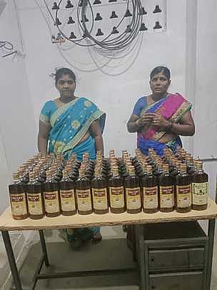 பறிமுதல் செய்யப்பட்ட மதுப் புட்டிகளுடன், கைது செய்யப்பட்ட வள்ளி, பூமாதேவி.