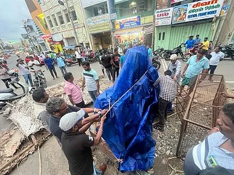 நாமக்கல்லில் சேதமடைந்த பெரியார் சிலையை நெகிழி தார்ப்பாய்க் கொண்டு மூடும் பொதுமக்கள்.