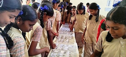 வடுகப்பட்டி அரசு மாதிரிப் பள்ளியில் திங்கள்கிழமை பழங்கால நாணயங்கள் கண்காட்சியைப் பாா்வையிட்ட மாணவிகள்.