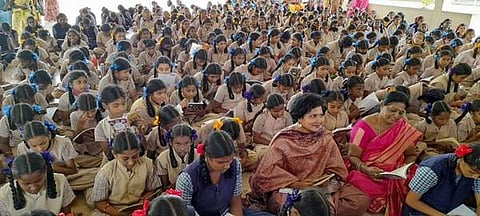 புதுக்கோட்டை வாசிக்கிறது நிகழ்ச்சியில் மாணவிகளுடன் புத்தகம் வாசிக்கும் மாவட்ட ஆட்சியர் கவிதா ராமு.