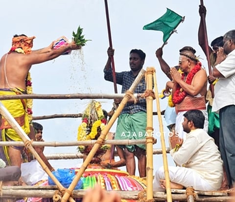 கோயிலின் விமானக் கலசத்துக்கு புனிநீா் ஊற்றும் சிவாச்சாரியா்.