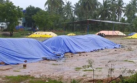 கொள்முதல் செய்யப்படாமல் மழை நீரில் நனையும் நெல்மணிகள்