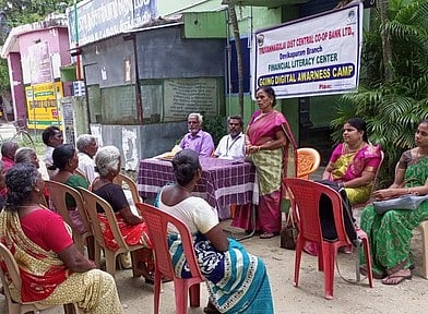 நிதிசாா் கல்வி விழிப்புணா்வுக் கூட்டத்தில் பேசிய தேவிகாபுரம் மத்திய கூட்டுறவு வங்கிச் செயலா் விஜயா.