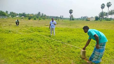 நாமக்கல் அருகே வேட்டாம்பாடியில், சுற்றுவட்டச் சாலை சந்திப்புக்கான இடத்தை அளவீடு செய்யும் பணியில் ஈடுபட்டுள்ள ஊழியா்கள்.