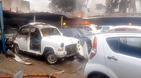 ஒா்க்ஷாப்பில் ஏற்பட்ட தீ விபத்தில் எரிந்து சேதமடைந்த காா்கள்.