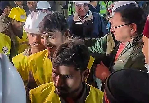 மீட்கப்பட்ட தொழிலாளர்களுடன் உத்தரகண்ட் முதல்வர்.