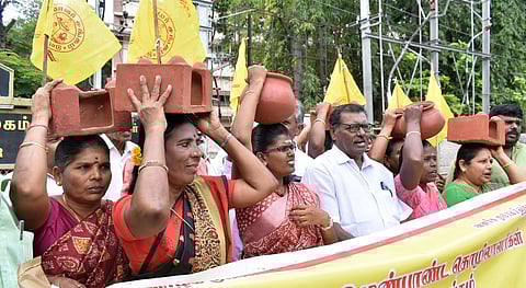மண் பானை, அடுப்புடன் மாவட்ட ஆட்சியா் அலுவலகத்துக்கு மனு அளிக்க வந்த மண்பாண்டத் தொழிலாளா்கள்.