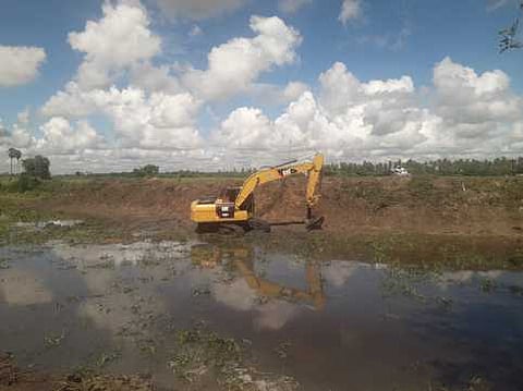 தகட்டூா் பகுதி முள்ளியாற்றின் குறுக்கேயுள்ள இயக்கு அணை அருகே நடைபெறும் ஆகாயத் தாமரைச் சொடிகளை அகற்றும் பணி.