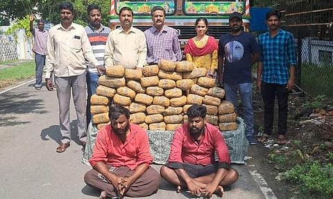 கைது செய்யப்பட்ட சதாசிவம், பாண்டீஸ்வரன் மற்றும் லாரியுடன் பறிமுதல் செய்யப்பட்ட கஞ்சா பொட்டலங்கள்.