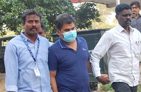 அமலாக்கத் துறை அதிகாரி அங்கித் திவாரி (முகக் கவசம் அணிந்திருப்பவா்).