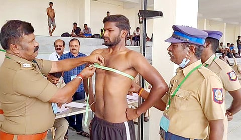 தோ்வில் பங்கேற்ற இளைஞருக்கு உடல் தகுதி சோதனை நடத்திய காவல் துறை அதிகாரி.