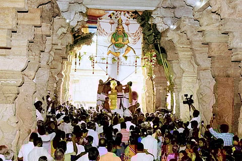 பங்குனித் திருவிழாவையொட்டி பெரிய கொடி மரத்தில் கருடன் உருவம் பொறித்த கொடியினை ஏற்றும் பட்டாட்ச்சாரியார்கள்.