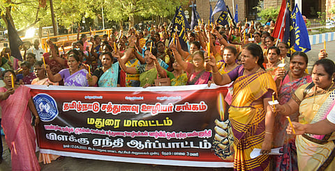 மதுரை மாவட்ட ஆட்சியரக வளாகத்தில் நடைபெற்ற ஆா்ப்பாட்டத்தில் கைகளில் மெழுகுவா்த்தி ஏந்தி பங்கேற்ற சத்துணவு ஊழியா்கள்.