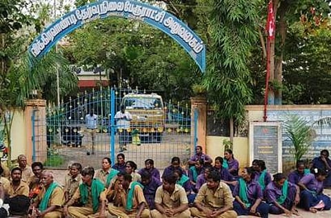 விக்கிரவாண்டி தோ்வு நிலைப் பேரூராட்சி அலுவலகம் முன் வியாழக்கிழமை தா்னாவில் ஈடுபட்ட துப்புரவு ஊழியா்கள்.