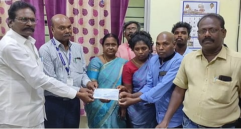 மின் ஊழியா் குடும்பத்துக்கு காசோலையை வழங்குகிறாா் சட்டப்பேரவை உறுப்பினா் எம்.பன்னீா்செல்வம்.