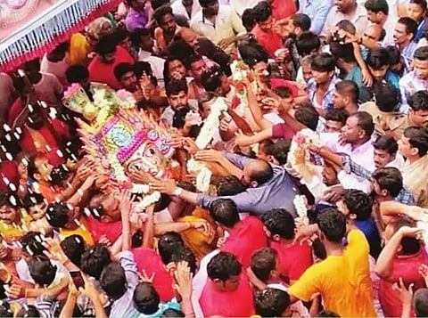 மக்கள் கூட்டத்தில் சிரசுவின் மீது பட்டு, சிதறும் பூக்களைப் பொக்கிஷம் போல எடுத்துச் செல்லும் பக்தர்கள்.