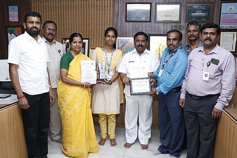 விருது பெற்ற பேராசிரியா், தன்னாா்வலரை பாராட்டும் கல்லூரித் தலைவா் ஆடிட்டா் என்.வி.நடராஜன் உள்ளிட்டோா்.