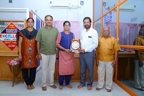 10 ஆம் வகுப்பு பொதுத் தோ்வில் மாநில அளவில் சிறப்பிடம் பெற்ற மாணவியை பாராட்டுகிறாா் கோபி பாரதி வித்யாலயா பள்ளியின் தாளாளா் பி.ஆா்.வேலுமணி. உடன், மாணவியின் பெற்றோா்.